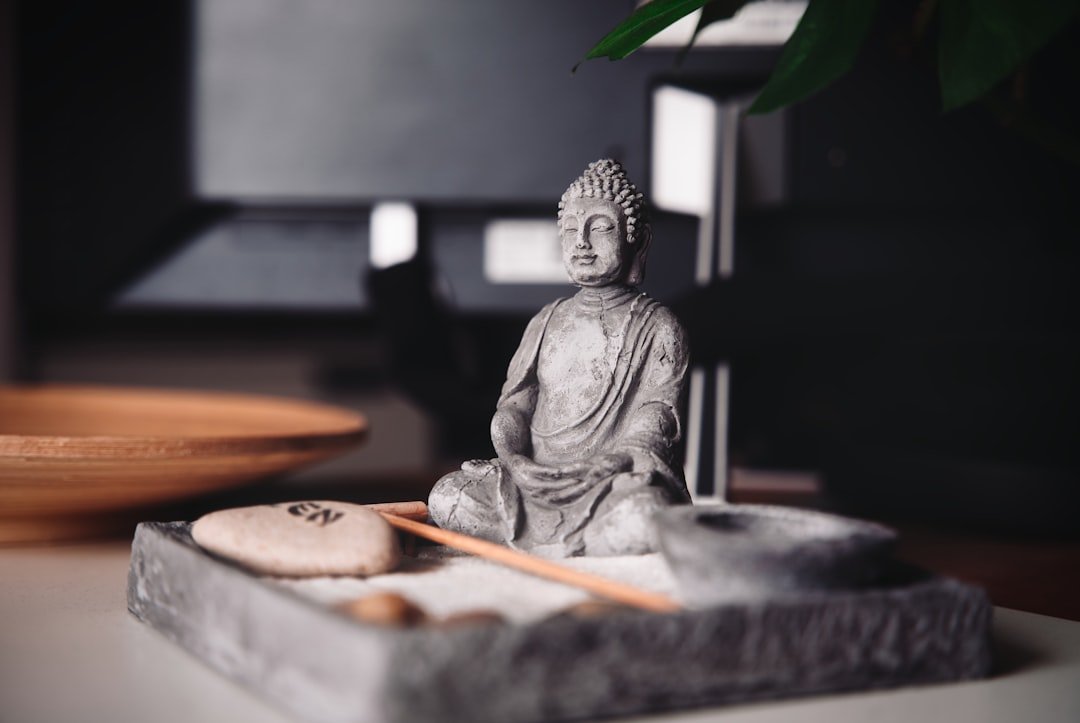 a-buddha-statue-sitting-on-top-of-a-table-mjcqxptwj20