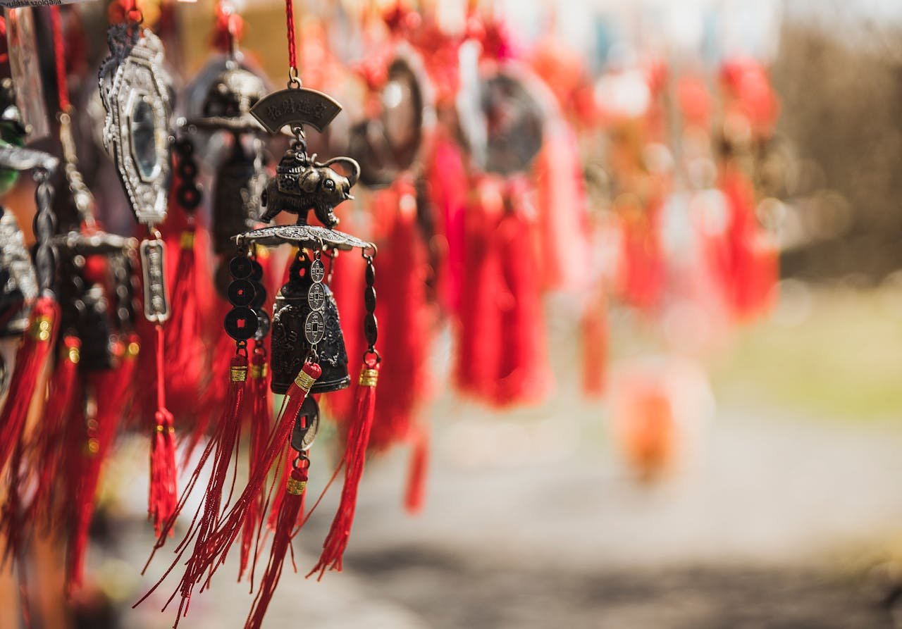 Intricate hanging ornaments with red tassels captured outdoors in daylight, conveying cultural richness.